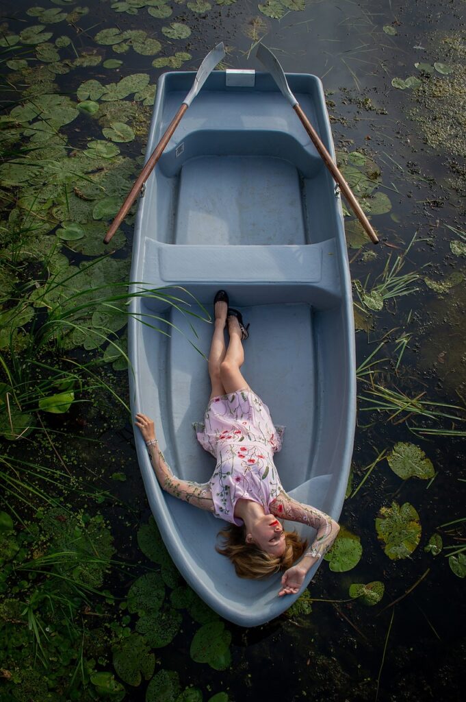 Mulher deitada num bote, deixa-se levar pela corrente. Destino?